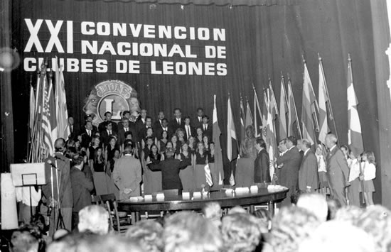 10 de abril de 1975. Ceremonia inaugural  de  la  XXI Convención Nacional de Clubes de Leones del Uruguay, en el  Teatro 25 de Mayo de la ciudad de Rocha. Interpretación del Himno Nacional por el Coro Municipal de Rocha.  En esta culminó su mandato como Gobernador del Distrito J3 del  Leonismo Nacional el compañero del Club de Rocha, León Fundador  Químico Farmacéutico Santiago Pradere Machado.